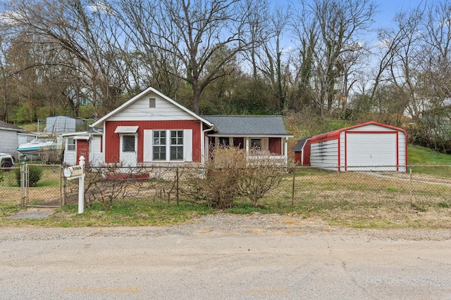 view of front of home with a detached garage, an outdoor structure, a gate, and a fenced front yard