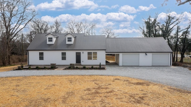 view of front of house with gravel driveway and metal roof