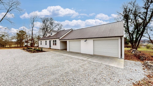 view of front of home featuring metal roof, driveway, and an attached garage