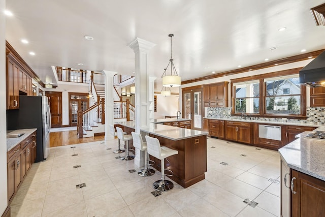 kitchen featuring a breakfast bar, backsplash, decorative columns, and light stone countertops