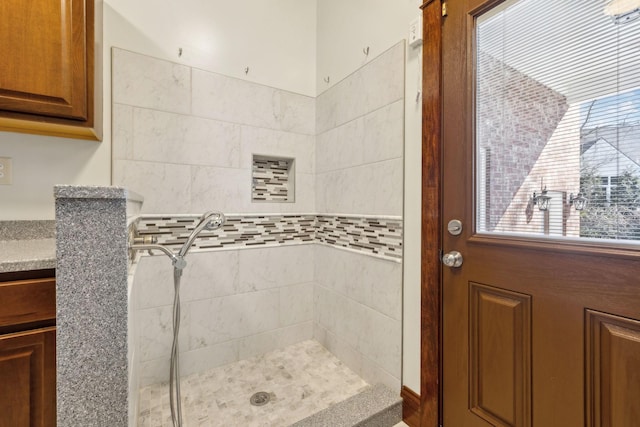 bathroom featuring tiled shower and vanity