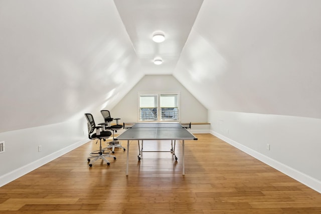 game room featuring light wood-style flooring, baseboards, and vaulted ceiling