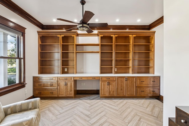 unfurnished office featuring ornamental molding, ceiling fan, built in desk, and recessed lighting