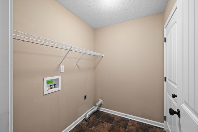 washroom featuring a textured ceiling, hookup for a washing machine, hookup for an electric dryer, laundry area, and baseboards