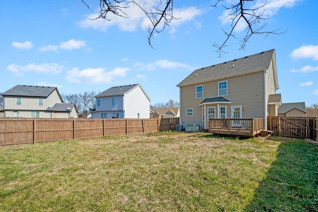 back of house with a deck, a yard, a fenced backyard, and a residential view