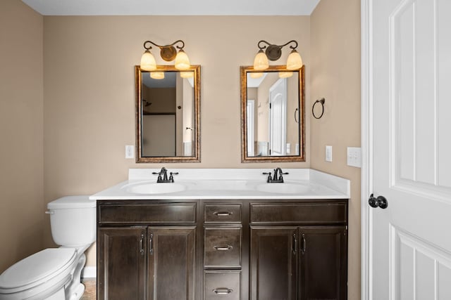 bathroom featuring a sink, toilet, and double vanity