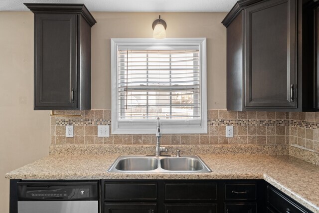 kitchen featuring tasteful backsplash, light countertops, a sink, and stainless steel dishwasher