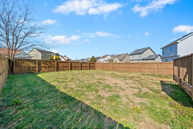 view of yard with a fenced backyard and a residential view