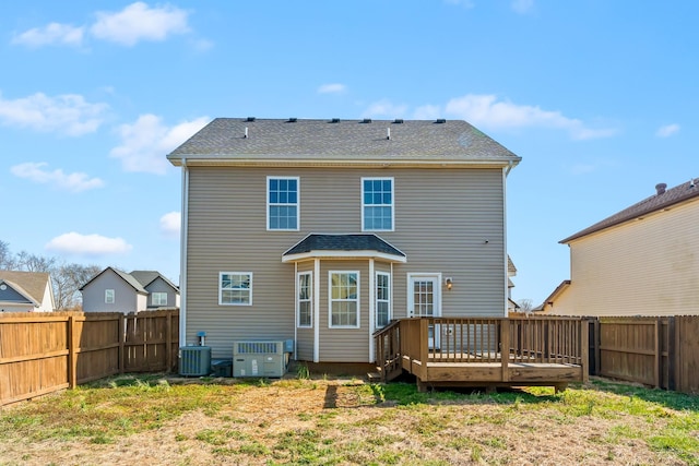 rear view of house featuring a fenced backyard, a wooden deck, and central air condition unit