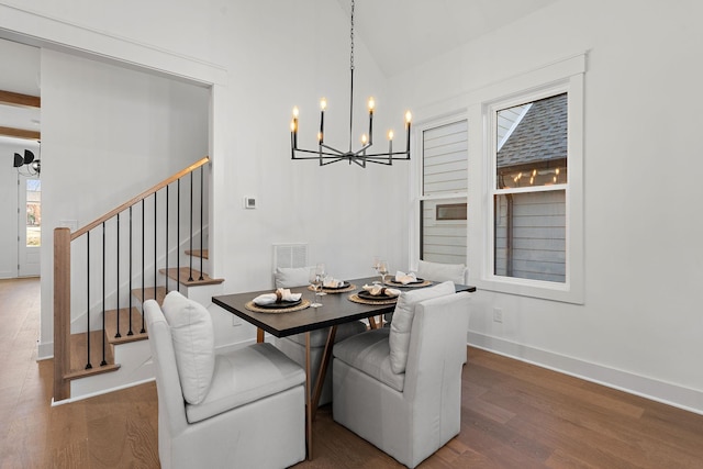 dining room featuring visible vents, stairway, an inviting chandelier, wood finished floors, and baseboards