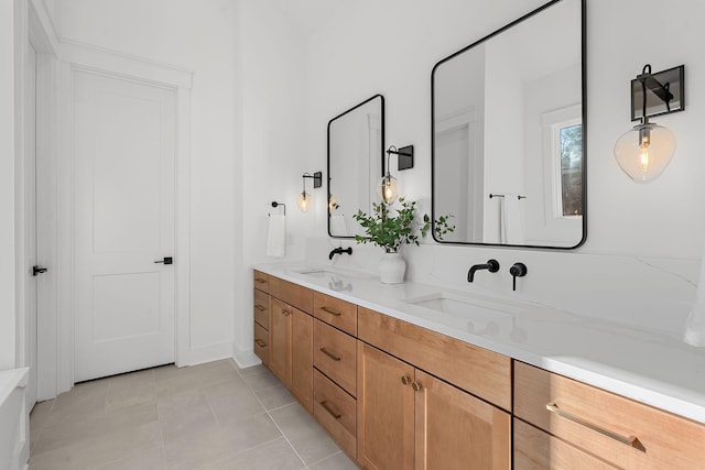 bathroom with tile patterned flooring, a sink, and double vanity