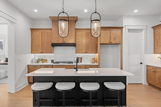 kitchen featuring light countertops, a sink, and light wood-style floors