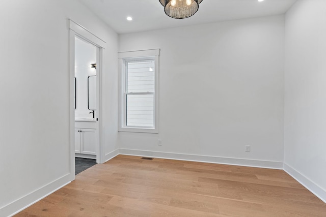 unfurnished room featuring visible vents, baseboards, wood finished floors, and recessed lighting