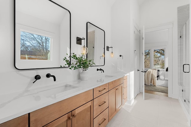 full bathroom featuring tile patterned flooring, double vanity, a sink, and ensuite bathroom