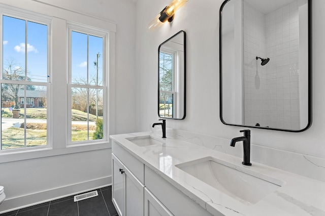 full bath with tile patterned flooring, a sink, visible vents, and baseboards