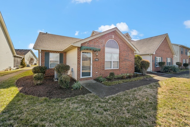 view of front of house featuring brick siding and a front yard