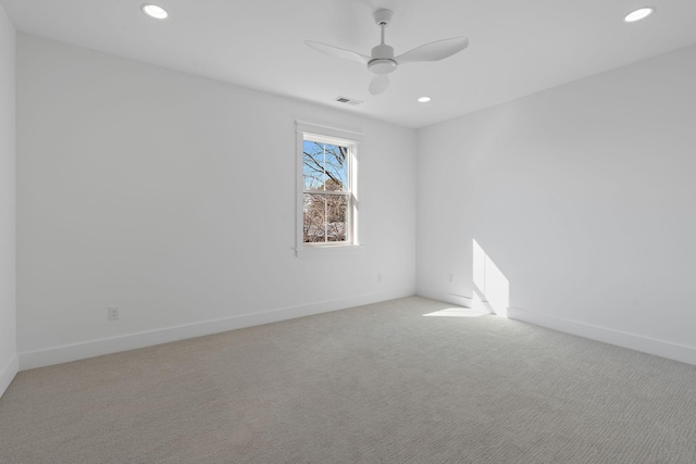 spare room featuring recessed lighting, light colored carpet, visible vents, a ceiling fan, and baseboards