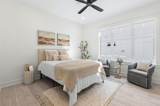 bedroom featuring baseboards, a ceiling fan, and light wood-style floors