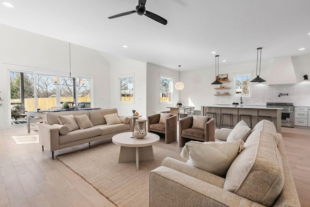 living room with ceiling fan, light wood-style flooring, and recessed lighting