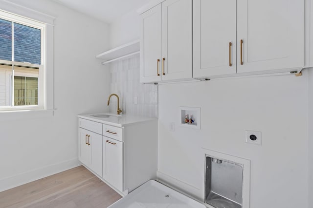 washroom featuring cabinet space, light wood-style flooring, hookup for an electric dryer, washer hookup, and a sink