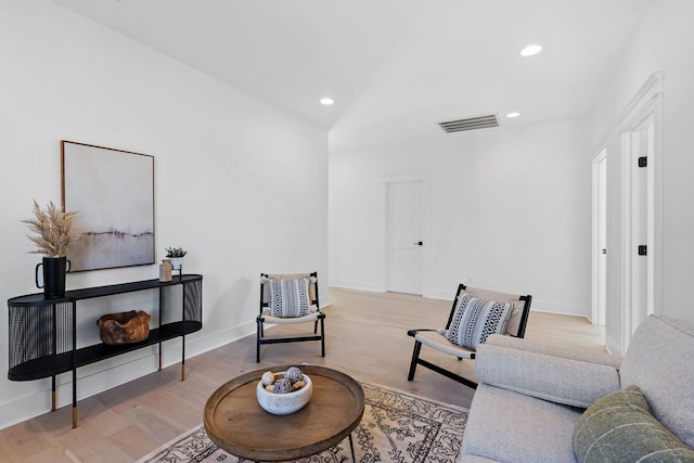 living area with recessed lighting, visible vents, baseboards, and wood finished floors