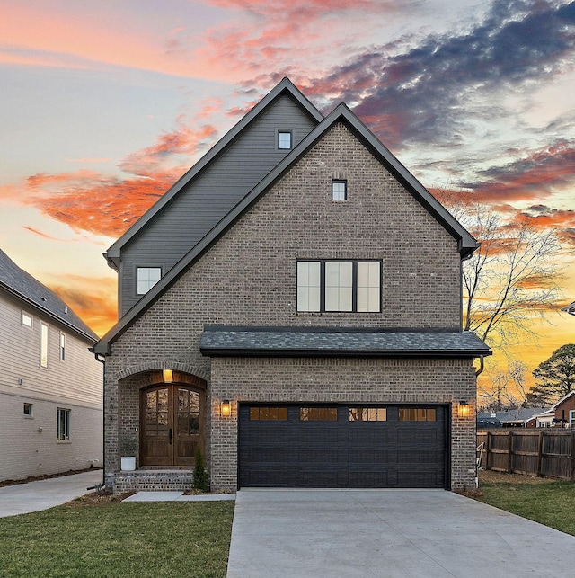 traditional-style home featuring brick siding, a yard, fence, a garage, and driveway