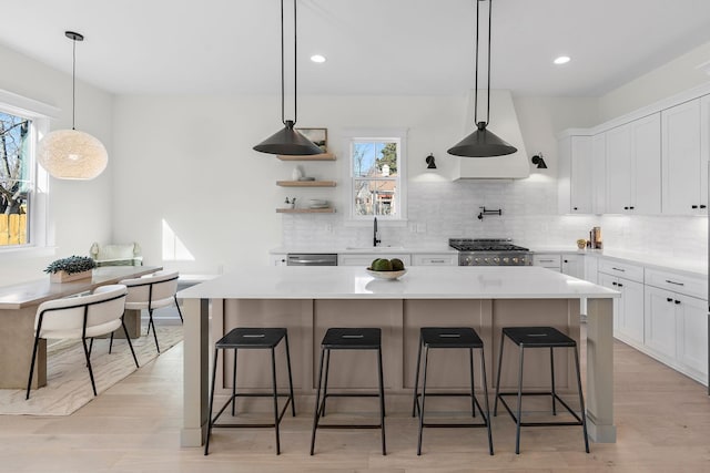 kitchen featuring tasteful backsplash, stove, a kitchen island, and white cabinetry