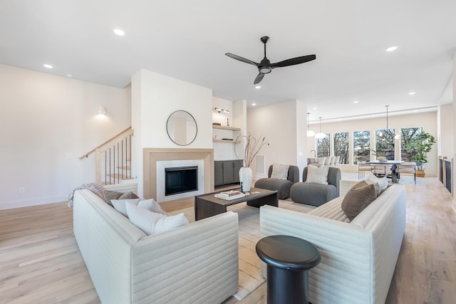 living area with ceiling fan, light wood finished floors, a fireplace, and recessed lighting