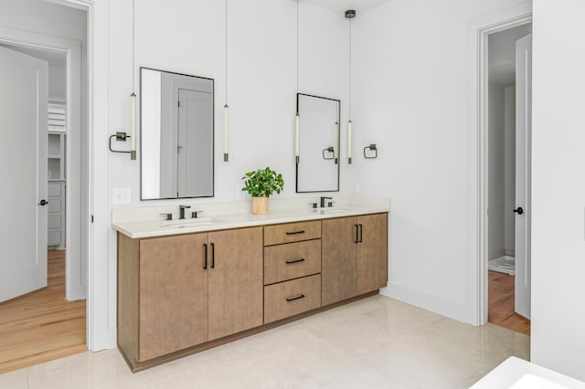 bathroom featuring a sink, baseboards, and double vanity