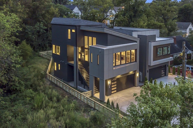 exterior space featuring driveway, a garage, and stairway