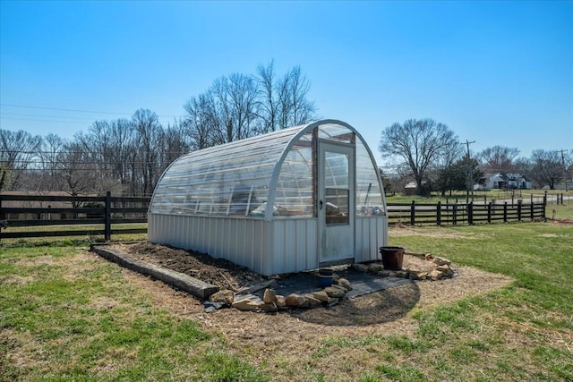 view of greenhouse featuring a yard and fence