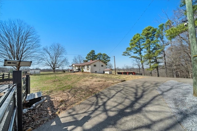 view of yard with aphalt driveway and fence