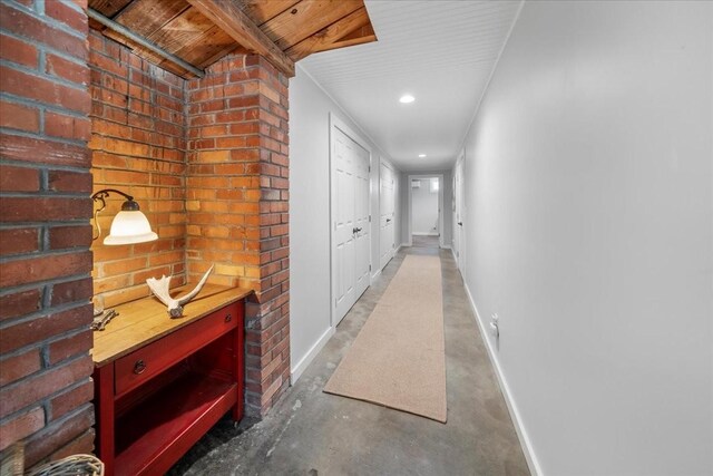 hallway featuring recessed lighting, baseboards, and concrete floors