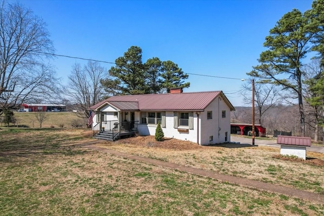 view of front of house featuring metal roof, covered porch, and a chimney