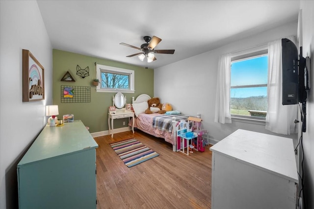 bedroom with ceiling fan, baseboards, and wood finished floors