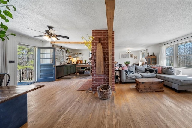 living room featuring a wealth of natural light, a textured ceiling, and wood finished floors