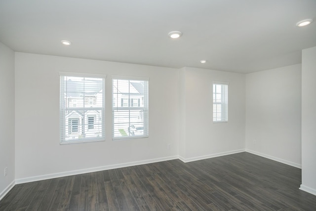 spare room with dark wood-style floors, baseboards, and recessed lighting