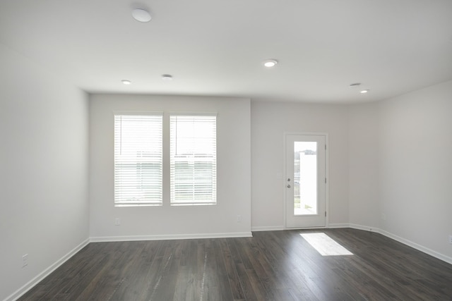 interior space featuring a healthy amount of sunlight, baseboards, dark wood-type flooring, and recessed lighting