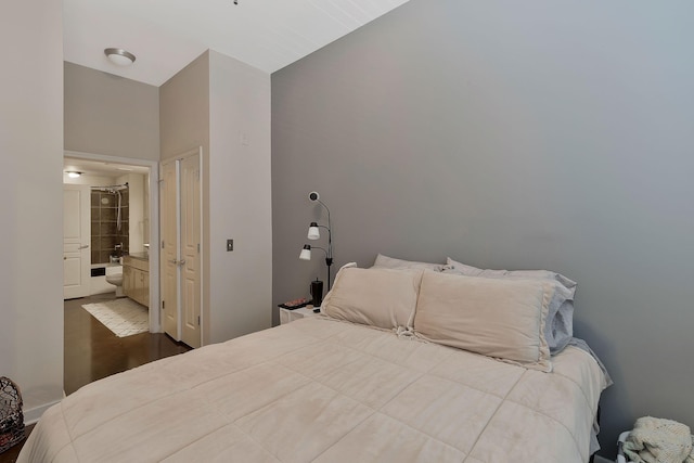 bedroom featuring ensuite bath and wood finished floors