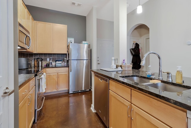 kitchen with visible vents, appliances with stainless steel finishes, finished concrete floors, a sink, and dark stone countertops