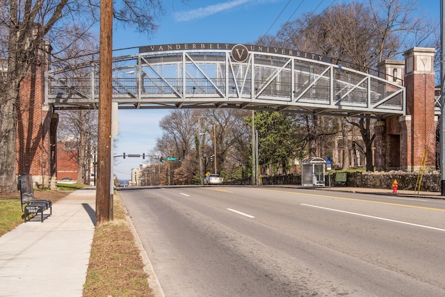 view of road featuring curbs, traffic lights, and sidewalks