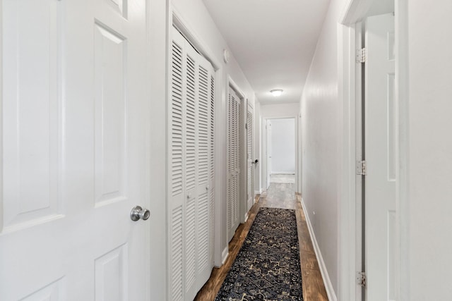 hall featuring baseboards and wood finished floors