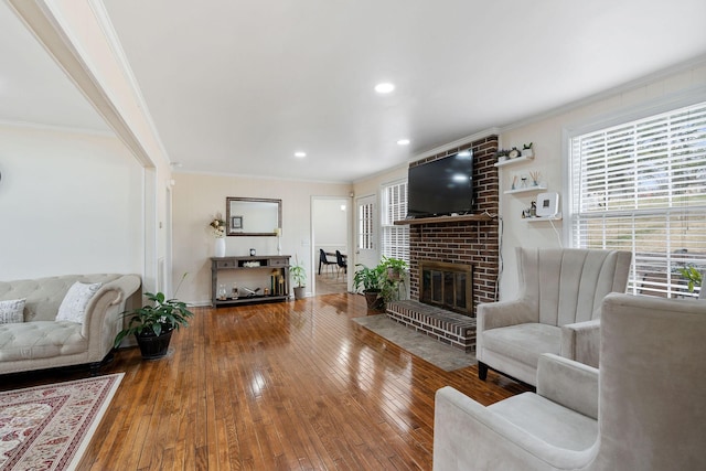 living area featuring ornamental molding, a wealth of natural light, and hardwood / wood-style flooring