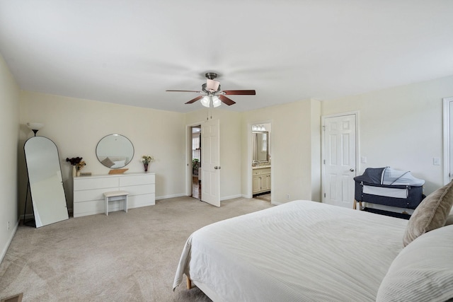 bedroom with a ceiling fan, light colored carpet, connected bathroom, and baseboards