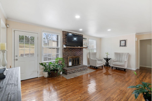 living room with hardwood / wood-style flooring, baseboards, a fireplace, and ornamental molding