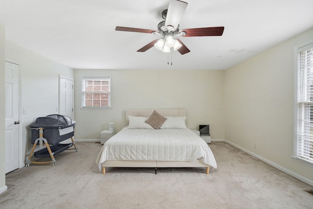 carpeted bedroom featuring multiple windows, ceiling fan, and baseboards