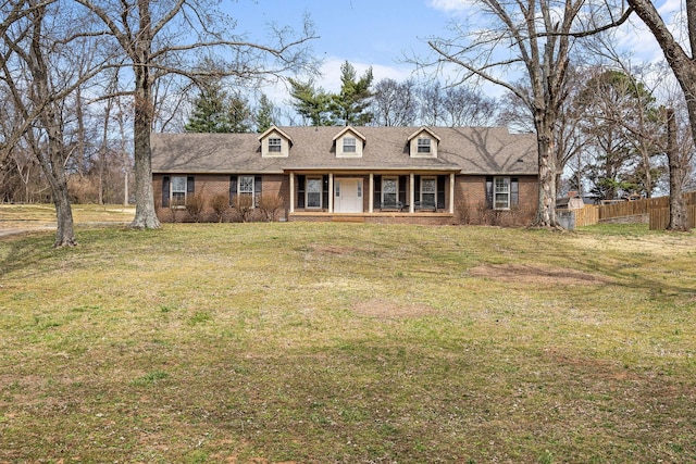 cape cod home with a front lawn, a porch, fence, and brick siding