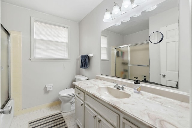 bathroom with toilet, vanity, tile patterned flooring, and a shower with shower door