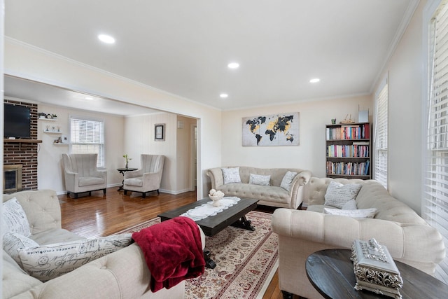 living area featuring recessed lighting, a fireplace, crown molding, and wood finished floors