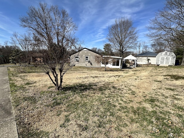 view of yard with an outdoor structure, a gazebo, and a storage unit